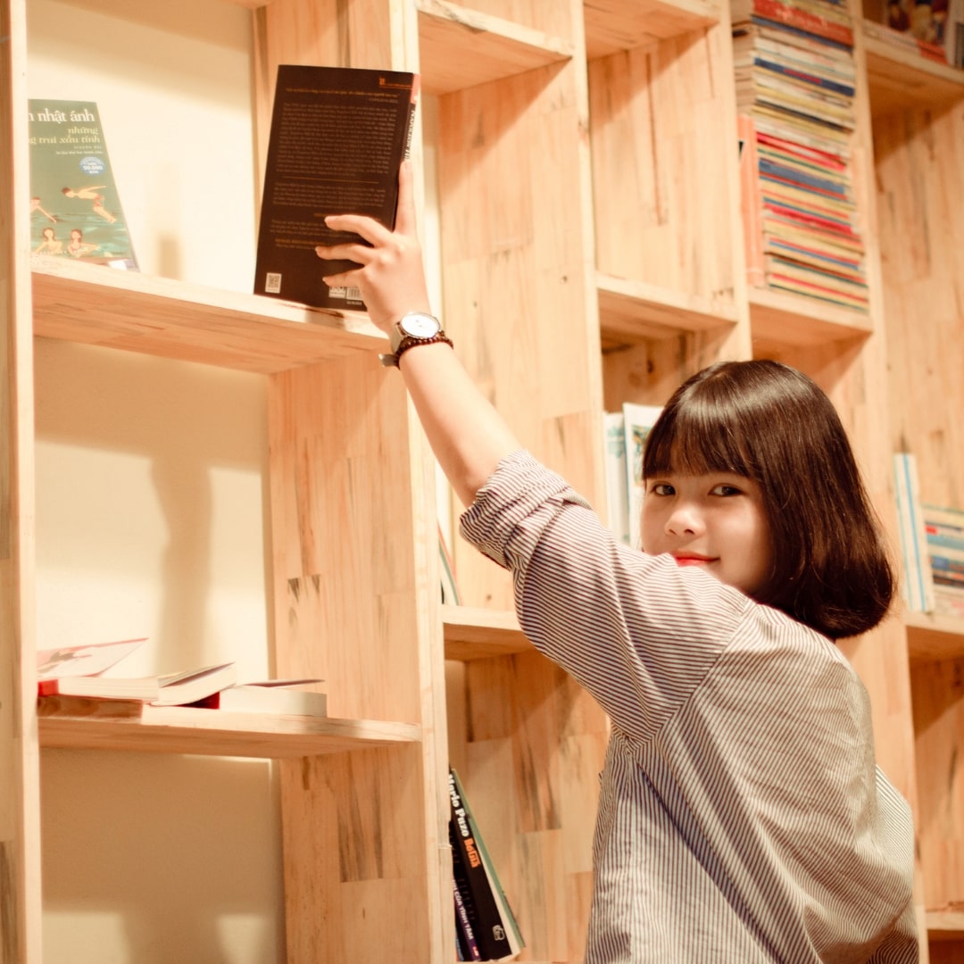 本を片付けている女性の画像