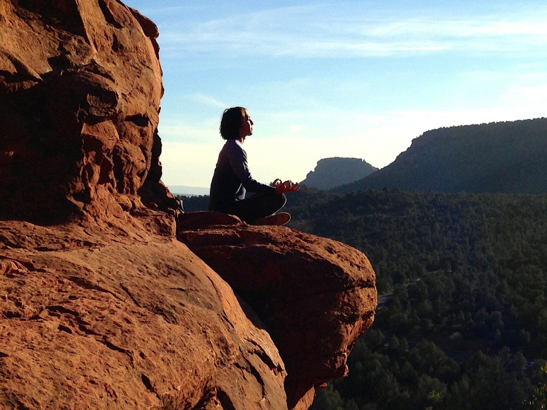岩場で瞑想しながらおまじないを唱えている女性の画像