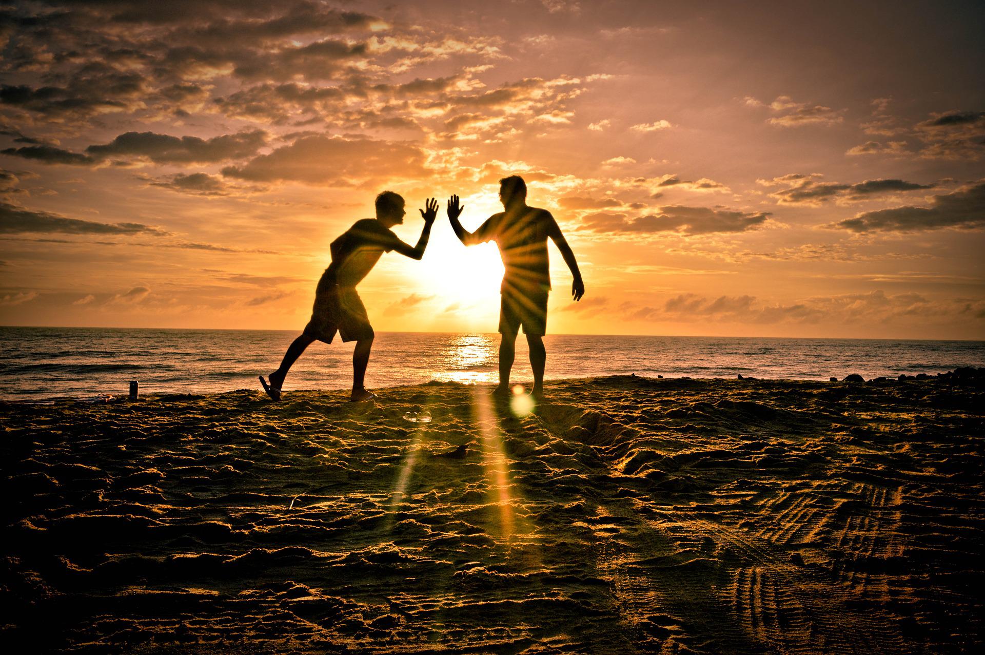 夕日のキレイな海に20代の男性二人が遊びにきている画像