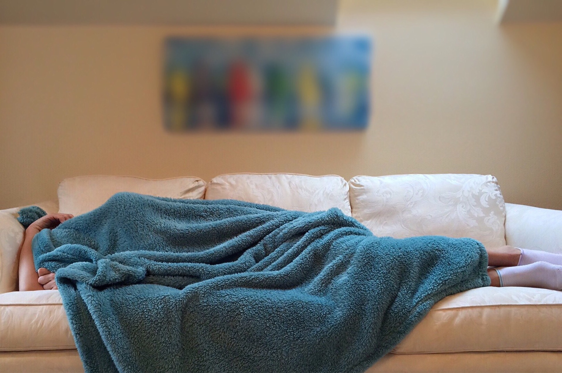 仕事に死ぬほど行きたくないと毛布に包まり寝ている人の画像