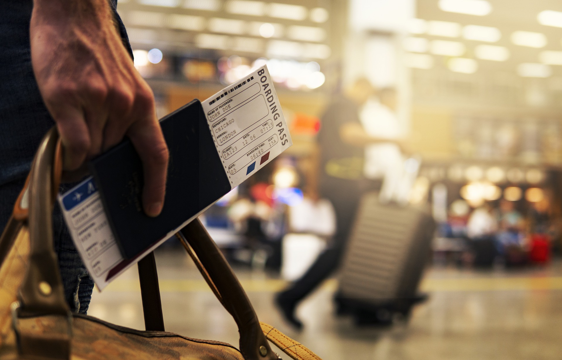 一人旅している男性が航空チケットを手に握りしめている画像