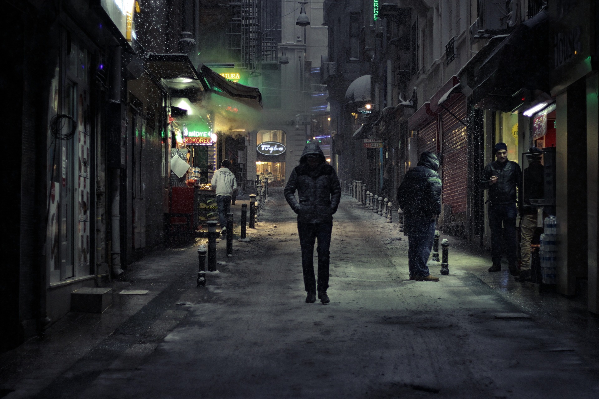 関わってはいけない雰囲気を出している黒ずくめの服装の男性が街中を歩いている画像