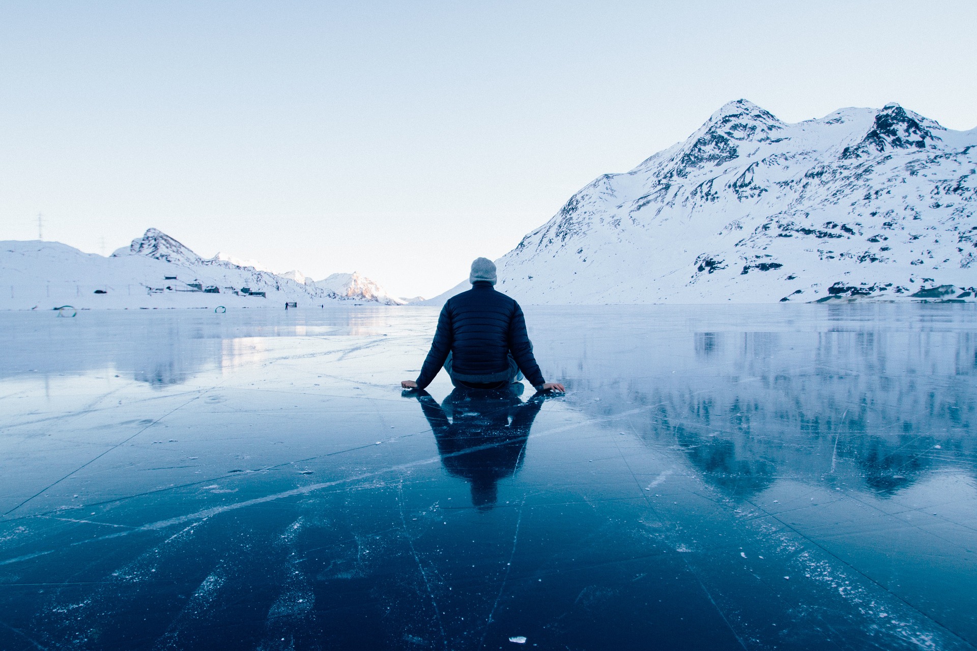 ツインレイ男性が氷の上に孤独そうに座っている後ろ姿の画像