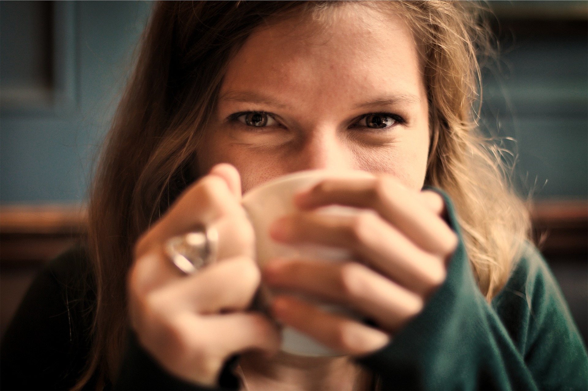 笑顔でコーヒーを飲んでいる女性の画像