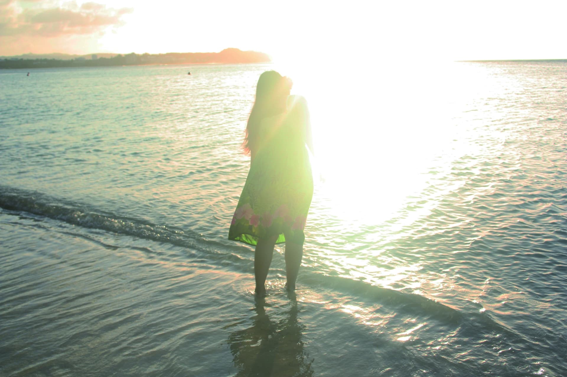 友達がいなくなり孤独そうに海辺に立っている女性のシルエットの画像